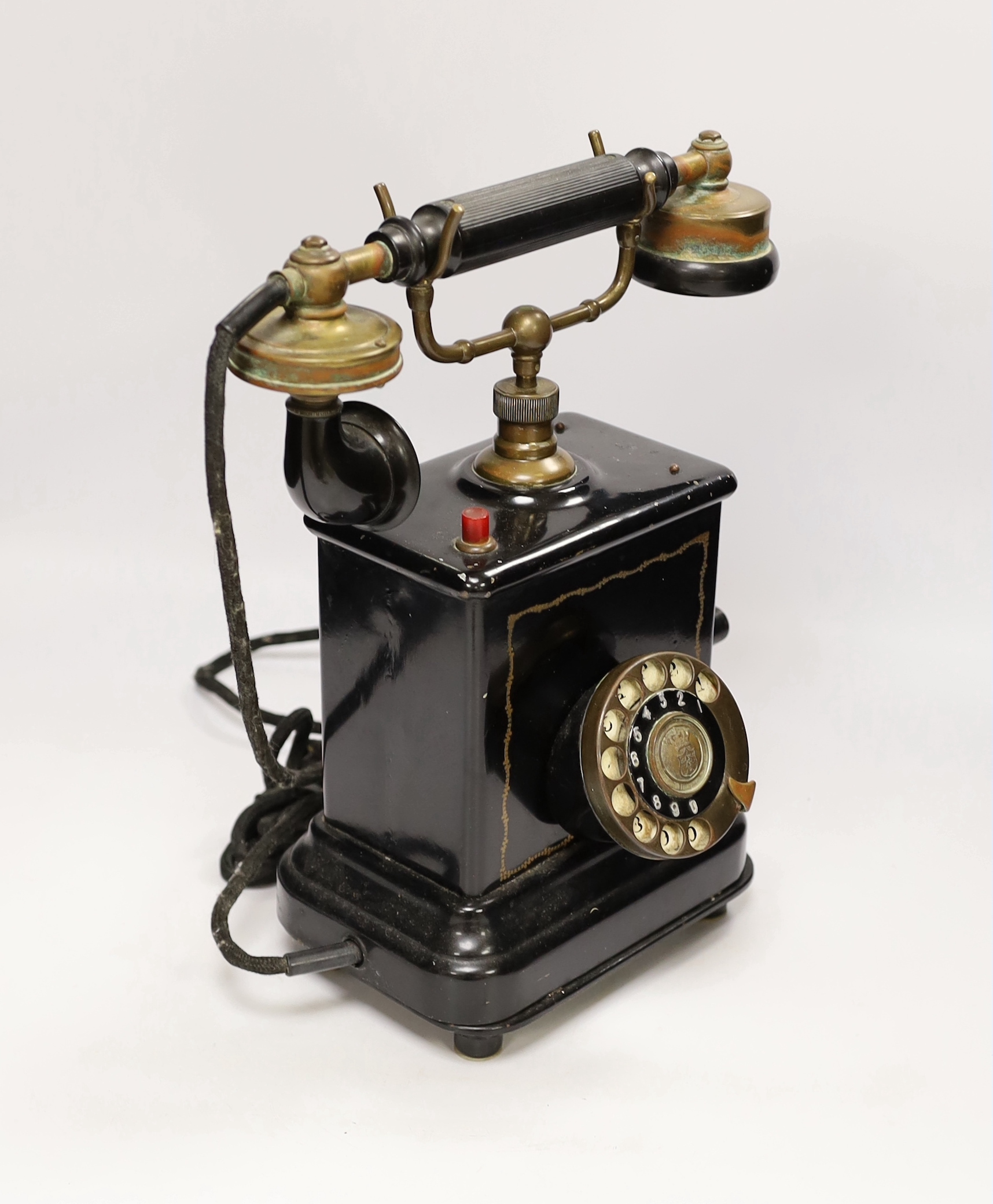 An early 20th century black enamelled metal telephone, 34cm high